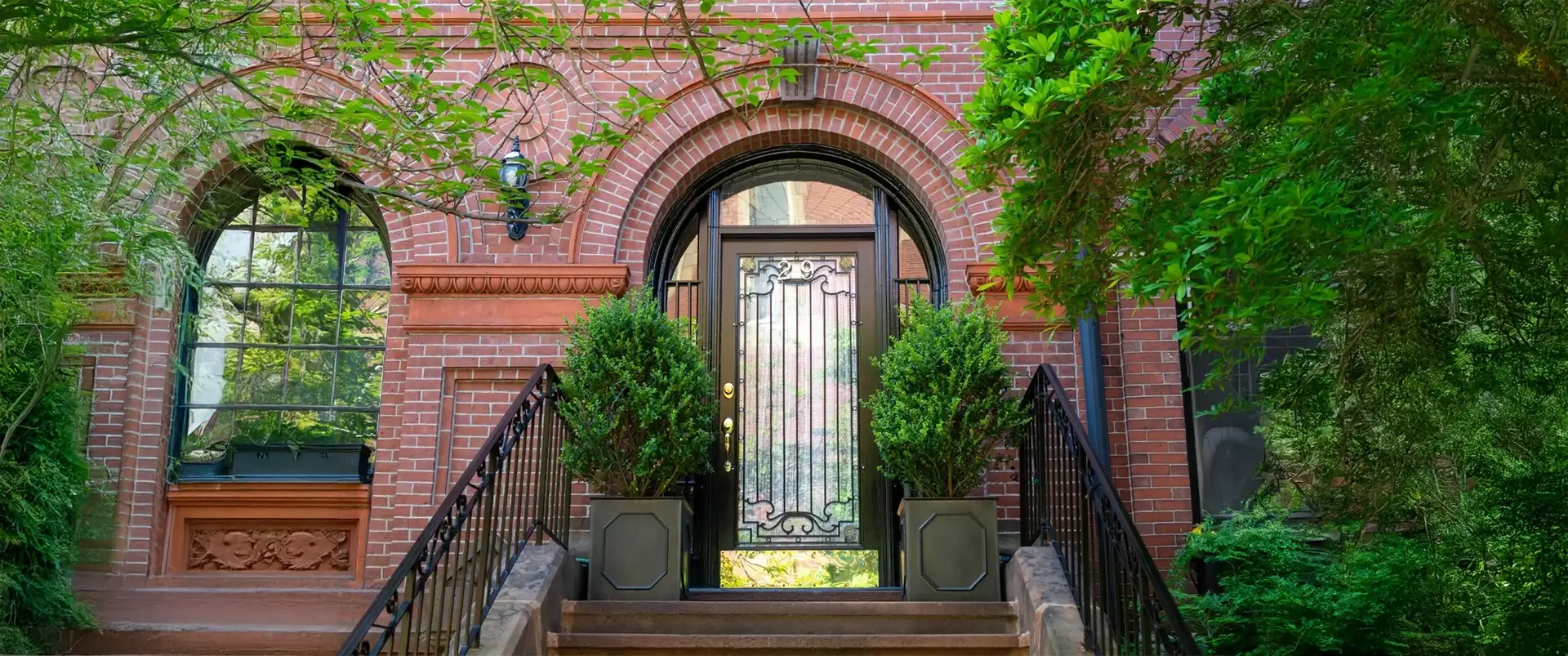 Harmony of nature and design at an elegant house entry with beautiful arched brick tuck pointing.