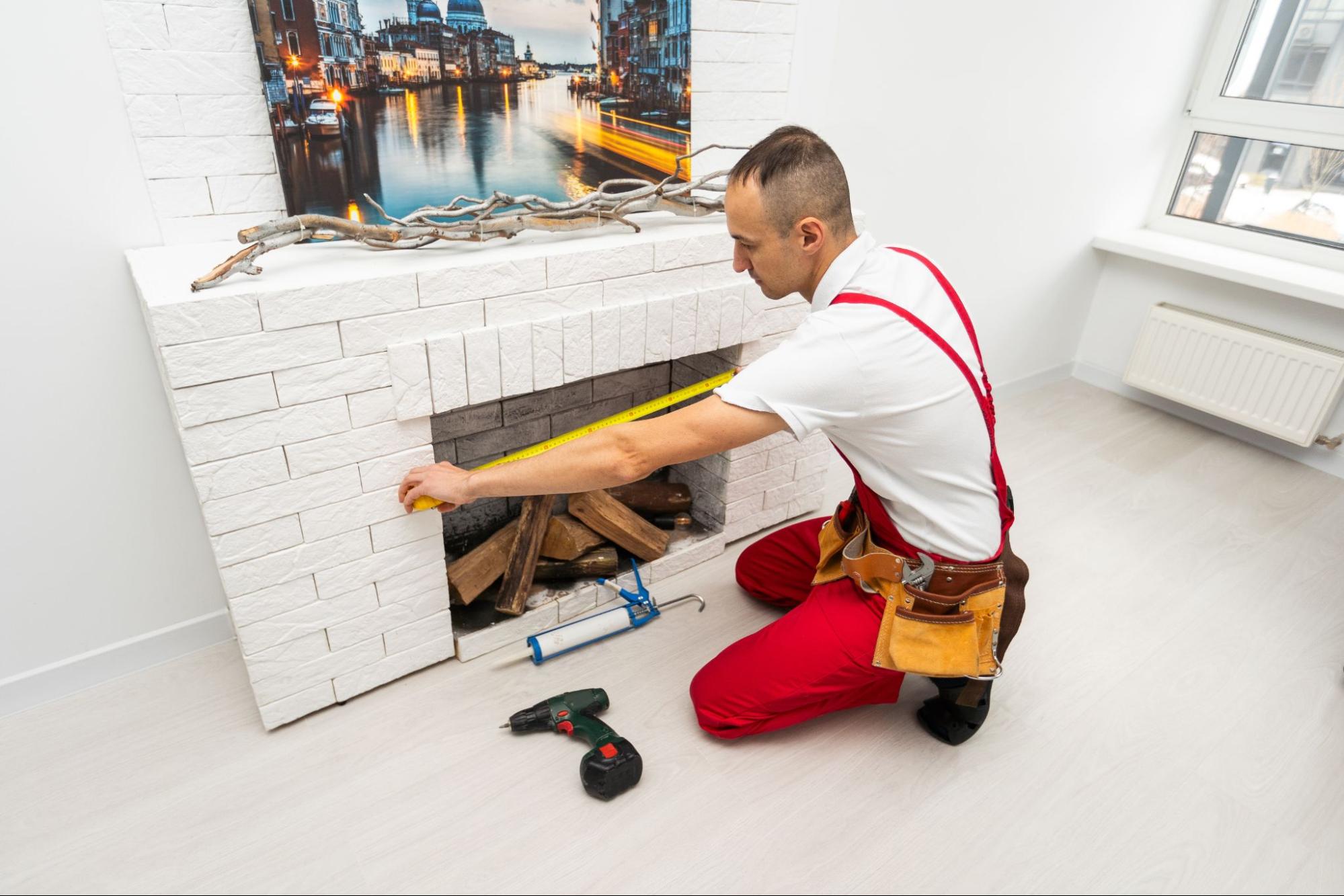 Service technician measures a residential fireplace for repair.