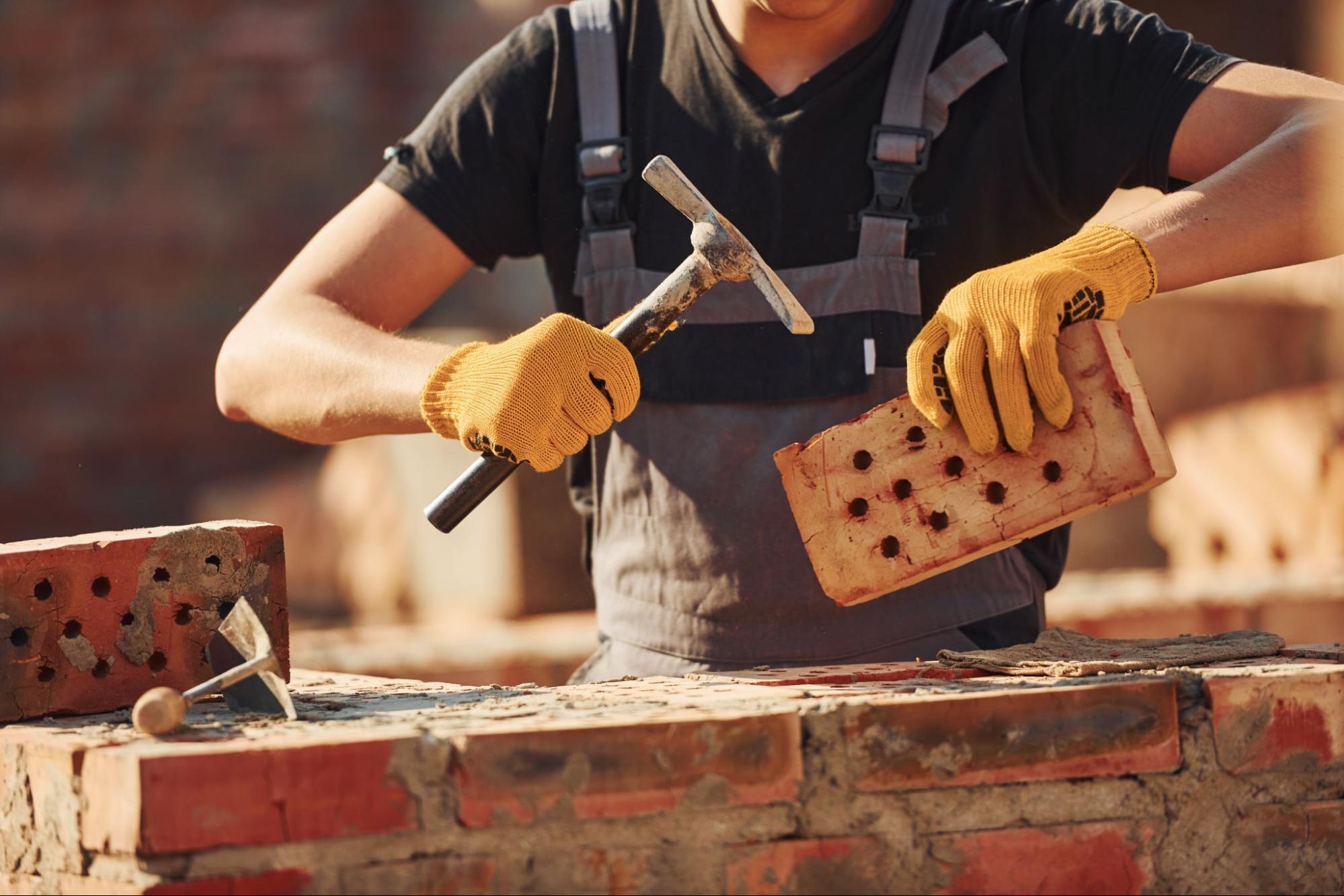 A masonry contractor builds a brick wall.