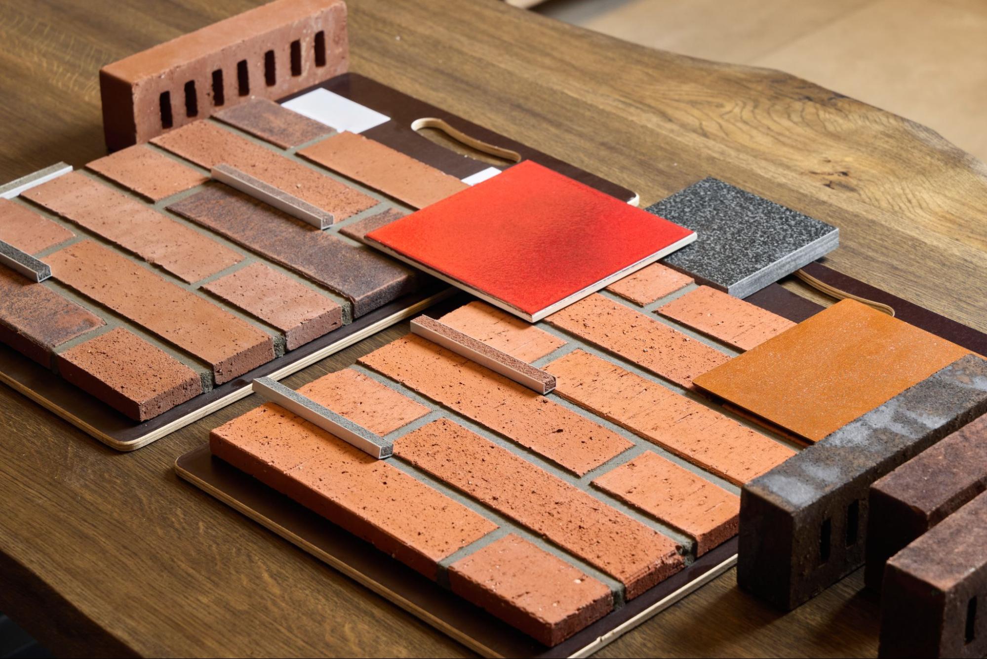 A group of brick veneer samples spread out across a table.