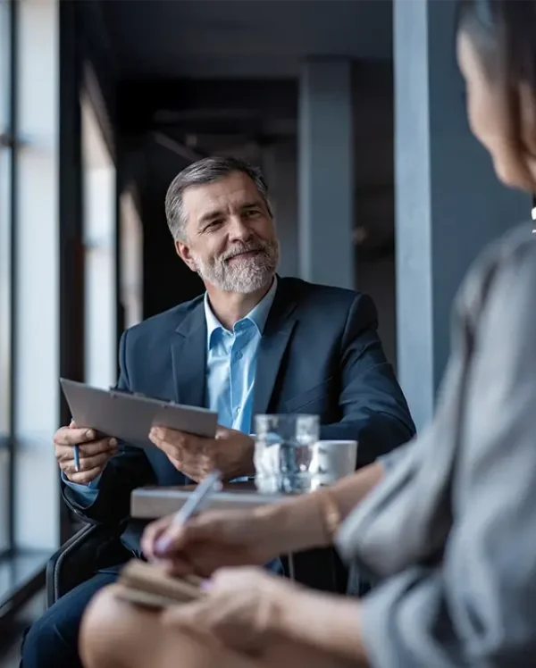 Image of mature businessman interviewing a female.