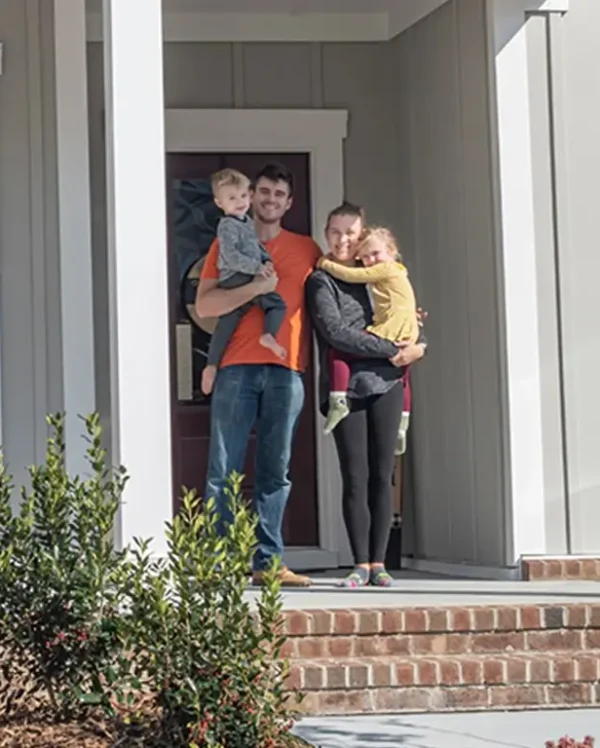 A family on the porch of their new first home.