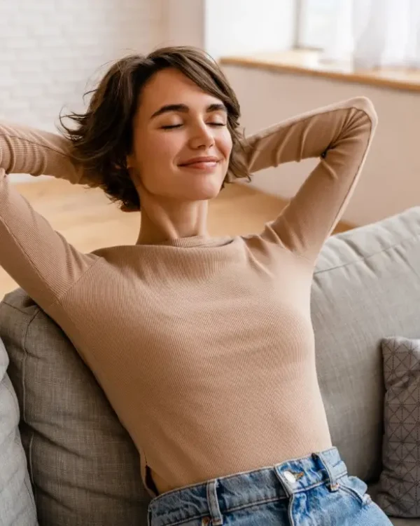 pretty young woman realxing at home sitting on sofa, smiling, happy, free time.